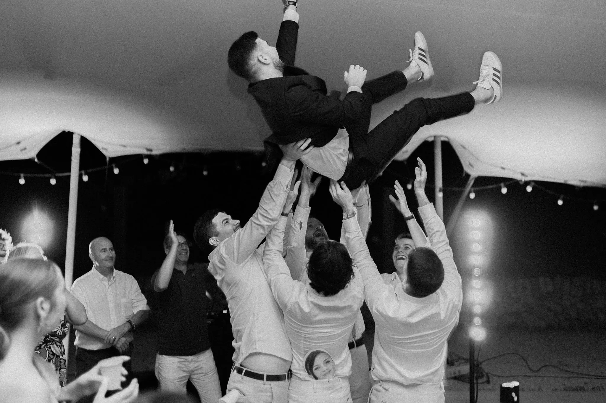 Le marié porté en l'air par ses amis, en fin de soirée